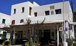 A white building with multiple windows, a signboard, and a no parking sign. - Gefyra Studios Filoti Naxos (Naxos)