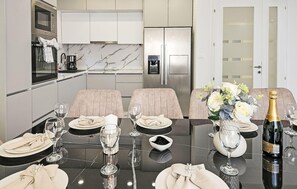 Eine moderne Küche mit Esstisch für zwei Personen, komplett mit Weingläsern, Tellern und einer Champagnerflasche.
