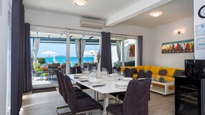 Un comedor con una mesa dispuesta para cuatro personas, un sofá y una cafetera.