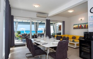A dining area with a table set for four, a sofa, and a coffee machine. - Lovely home in Zaboric with private swimming pool, can be inside or outside (Zaboric)
