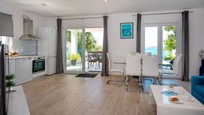 Una cocina moderna con comedor, vista al mar y balcón.