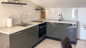 A modern kitchen with a built-in oven, a sink, and a countertop. - Beautiful apartment in Raslina with WiFi (Raslina)