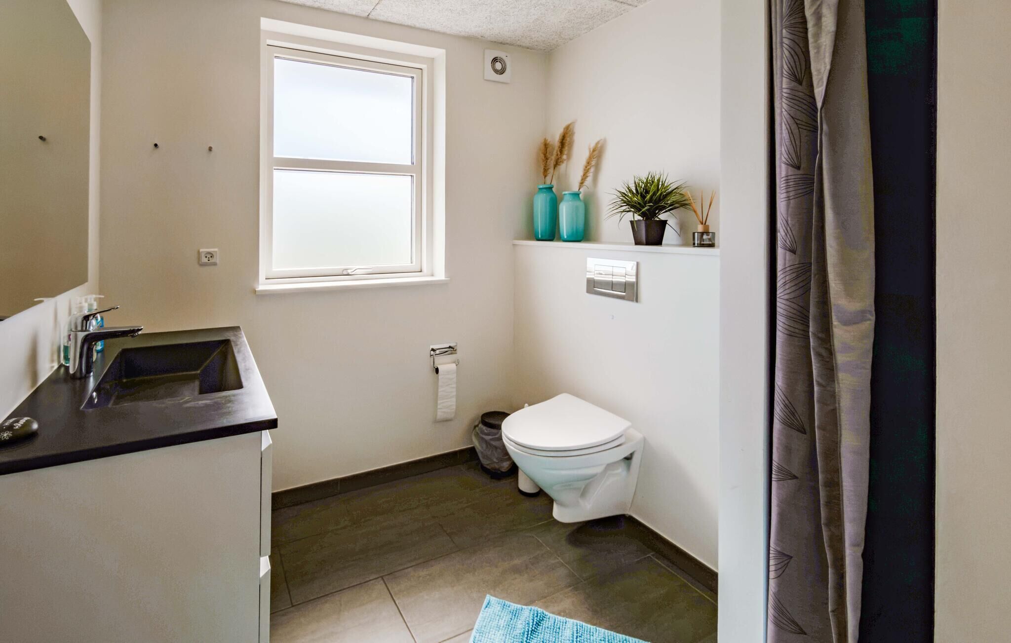 Un baño pequeño con lavamanos, inodoro y ventana.