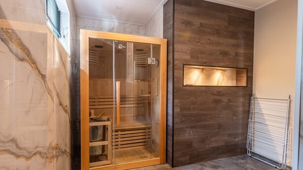 A walk-in closet with a glass door, a wooden interior, and a marble wall. - Vakantiepark De Wiltzangh - De Havezate Wellness (Ruinen)