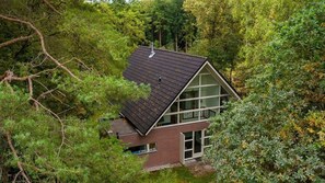 Ein modernes Haus, umgeben von dichtem Wald.