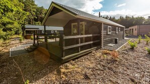 A cabin with a porch, a covered entryway, and a small deck. - De Wiltzangh - Veenborg Lodge | 4p (Ruinen)