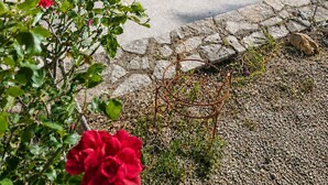 Ein gepflasterter Weg mit einer Steinsäule, einer Schwan-Statue und Blick aufs Meer.