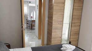 Ein Schlafzimmer mit einem Bett, einem Kleiderschrank und einem Spiegel.