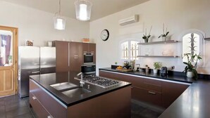 A modern kitchen with a central island, stainless steel appliances, and pendant lighting. - Villa with Pool in Châteauneuf-du-Pape (Chateauneuf-du-Pape)