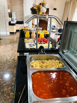 Montaje tipo bufé con diversos alimentos y bebidas.