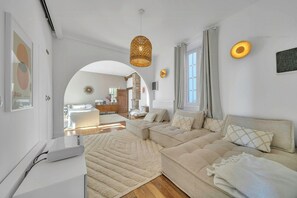 Una sala moderna con un sofá modular, una mesa de centro blanca y un ventanal grande.