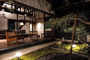 Un bâtiment de style japonais traditionnel, doté de tatamis, d’une terrasse en bois et d’un bassin à carpes koï.