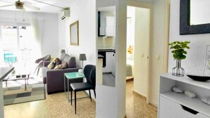 En moderne lejlighed med opholdsstue, køkken og spiseområde.