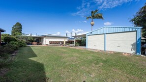 A residential property with a covered patio, a garage, and a lawn.