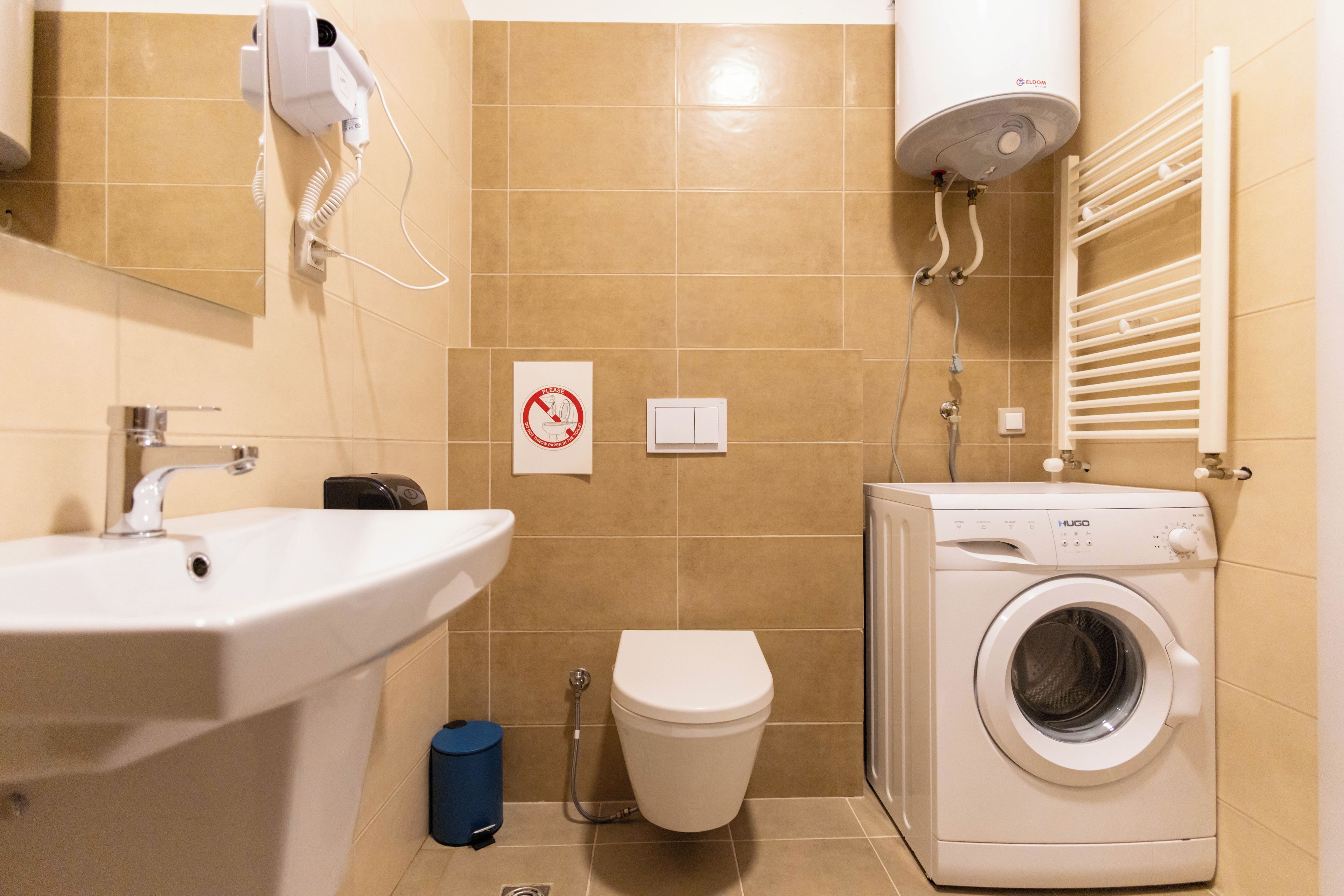 Un bagno con lavandino, wc e lavatrice.
