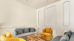 A modern living room with a sofa, armchairs, and a coffee table. - Country Inn Katra (Reasi)