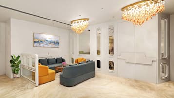 A modern living room with a sofa, armchairs, a coffee table, and a potted plant.