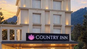 Un edificio de varios pisos con un letrero que dice 'Country Inn' en la entrada.
