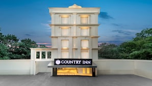 A multi-story building with a sign reading 'COUNTRY INN' and a balcony area. - Country Inn Katra (Reasi)