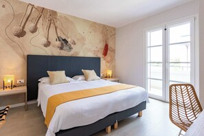 Ein modernes Schlafzimmer mit einem großen Bett, Nachttischen, einem Sessel und einem großen Fenster.