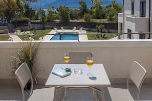 A balcony with a table, two chairs, a potted plant, a book, and two glasses of wine. - Appartamento "Isola di Ustica 2" (Carini)