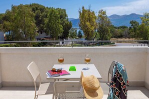 A balcony with a table, two chairs, a hat, and two glasses of wine. - Appartamento "Isola di Marettimo 2" (Carini)