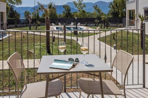 A terrace with a table, two chairs, and two wine glasses. - Appartamento "Isola di Alicudi 1" (Carini)