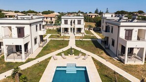 A residential area with modern houses, a central swimming pool, and a clear sky. - Appartamento "Isola di Alicudi 1" (Carini)