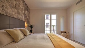 A bedroom with a large bed, a headboard, a potted plant, a window with a view, and a door. - Appartamento "Isola di Ustica 1" (Carini)