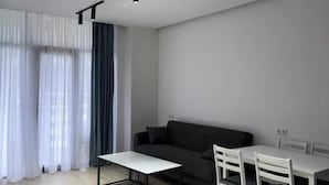 Una sala de estar moderna con sofá, mesa de comedor, sillas y una mesa de centro.