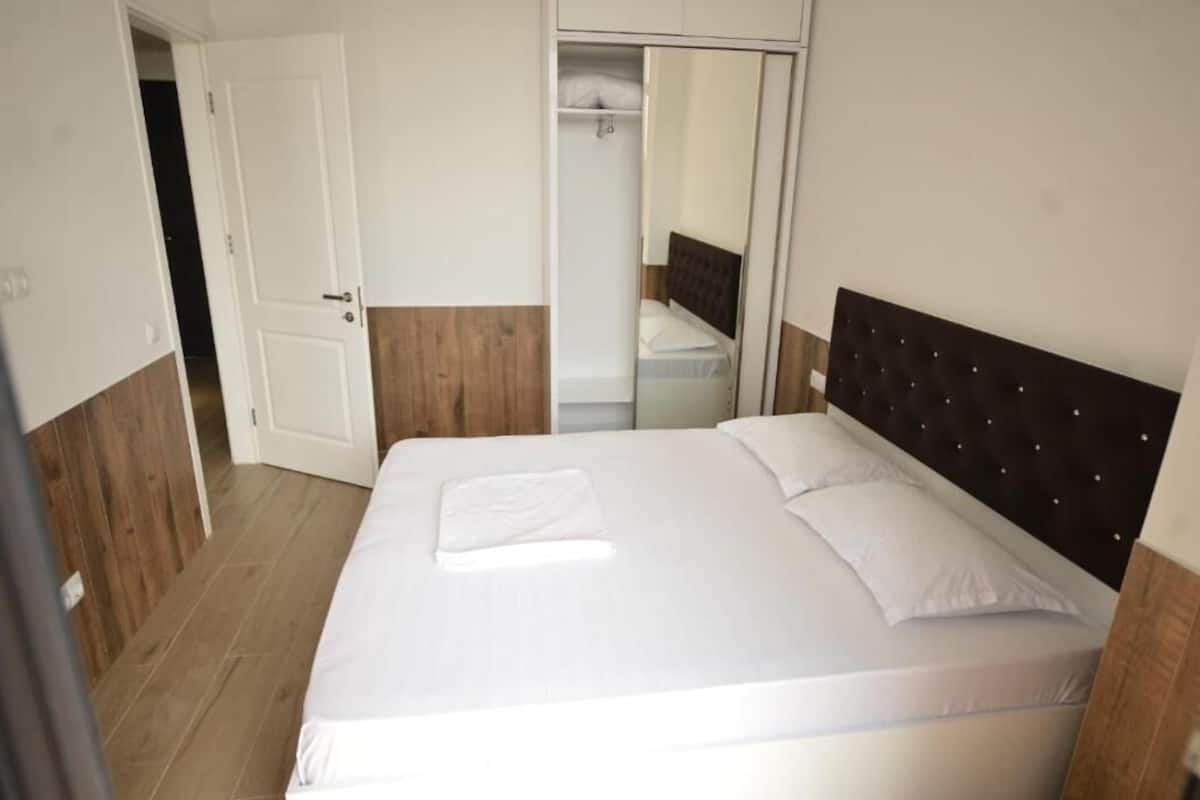 Un dormitorio con cama, armario y espejo.