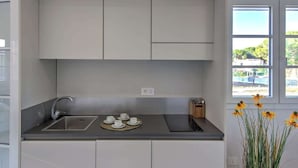 Een moderne keuken met een centraal eiland, een spoelbak en een raam met uitzicht.