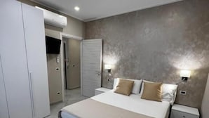A modern bedroom with a bed, bedside tables, a wardrobe, and a ceiling light. - B&B Lamezia Central Airport (Lamezia Terme)