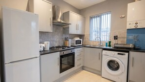 Una cocina moderna equipada con refrigerador, microondas, horno y lavadora.