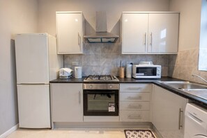 A modern kitchen with a refrigerator, stove, oven, microwave, and dishwasher.