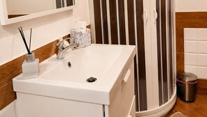 A bathroom with a white sink, a mirror, a towel rack, a toilet, and a shower with vertical stripes. - Studio with double bed 5 minutes from Florence Campo di Marte station (Firenze)