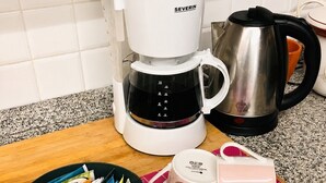A kitchen with a coffee maker, a kettle, and a mug on a table. - Studio with double bed 5 minutes from Florence Campo di Marte station (Firenze)