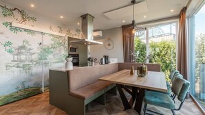 A modern kitchen with a built-in oven, microwave, and a hanging light fixture. - De Wiedense Meren - Villa Waterrijk MIVA | 3p (Wanneperveen)