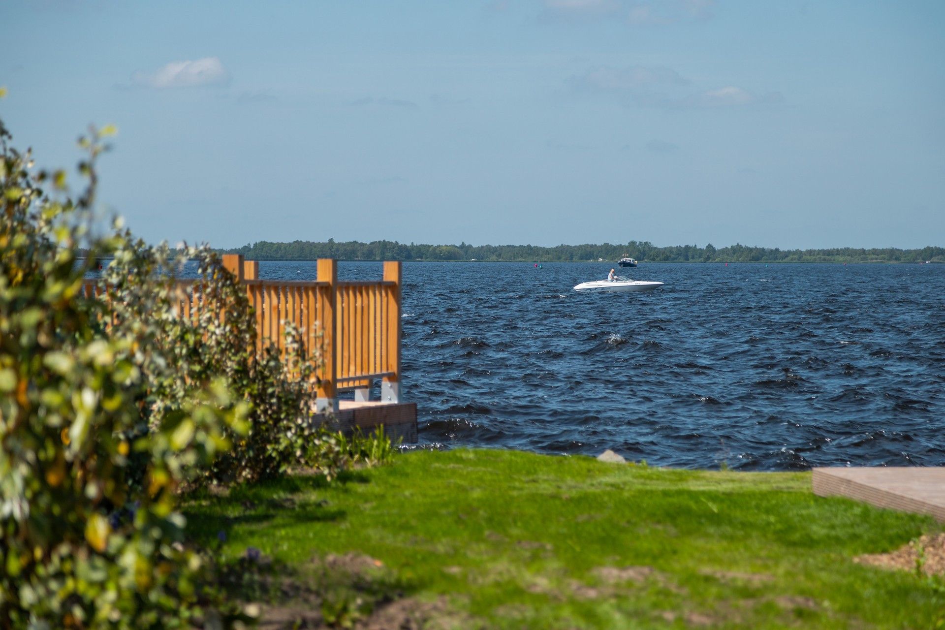 Une étendue d’eau avec un bateau et une structure en bois au premier plan.