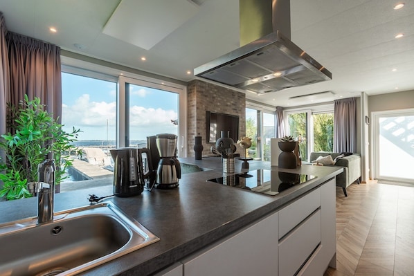 A modern kitchen with a large window, a built-in stove, and a sink.