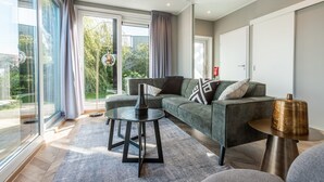 A modern living room with a sofa, a coffee table, and a lamp.