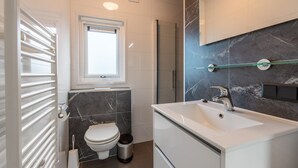Un baño moderno con inodoro, bidé y lavamanos.