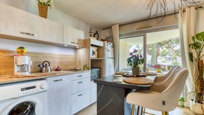 Una cucina moderna con lavatrice integrata, macchina del caffè e forno a microonde.