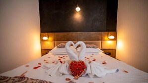 A neatly made bed with a heart-shaped object and towels arranged in a heart shape. - Hotel Corsa Managalia (Mangalia)