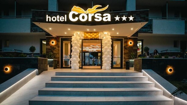 A hotel entrance with a modern facade, a staircase leading up to the doors, and a sign above the entrance. - Hotel Corsa Managalia (Mangalia)
