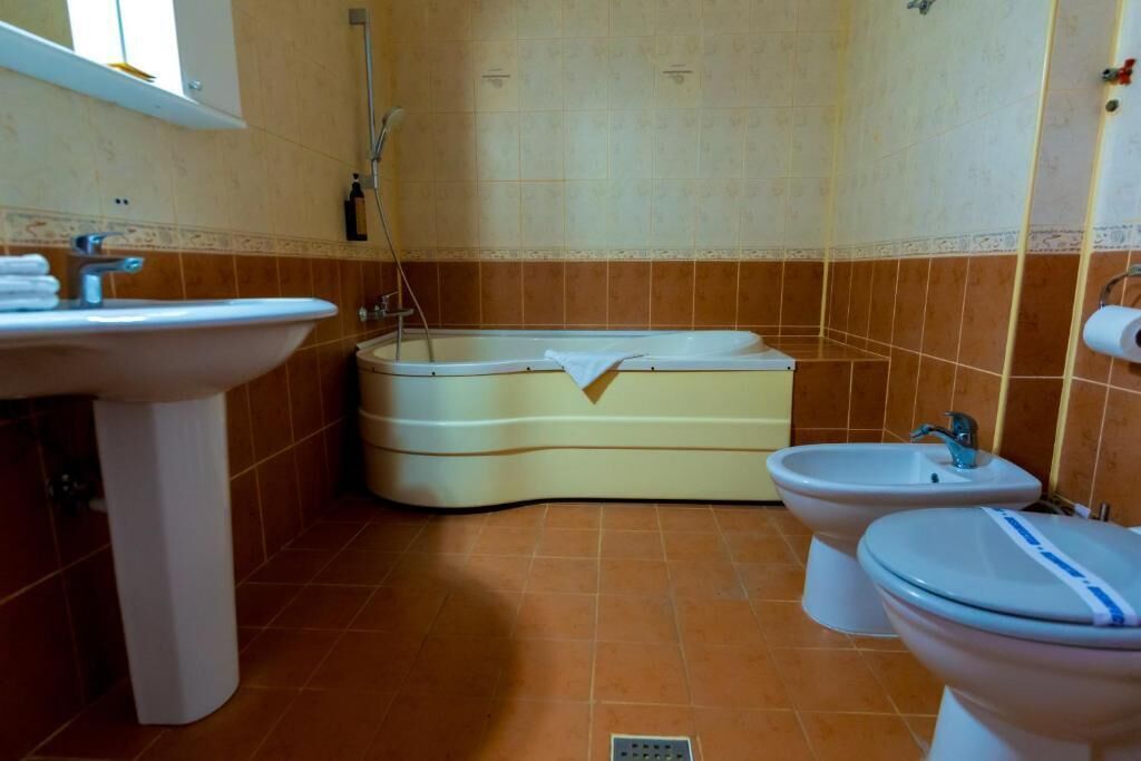 A bathroom with a sink, bathtub, bidet, and toilet.