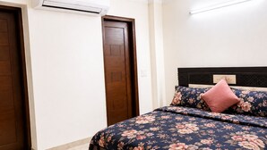Un dormitorio con una cama, una puerta de madera y un equipo de aire acondicionado.