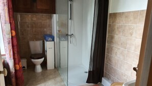 Un baño con inodoro, ducha y lavamanos.