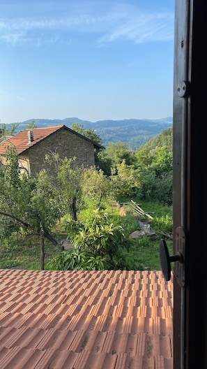 A rustic stone building with a tiled roof, surrounded by lush greenery and hills in the background. - Private property, two houses, gym, pool and outside bar in stunning surrounding (Bosia Cuneo)