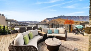 A deck with outdoor furniture, a grill, and a view of mountains. - Alpine 75 Residence - Queenstown Hill 5 Bed (Queenstown)
